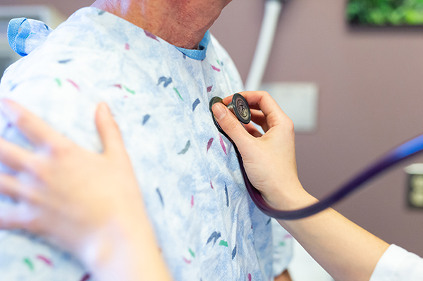 UVA Surgical Oncology Division provider listens to a patient's heartbeat
