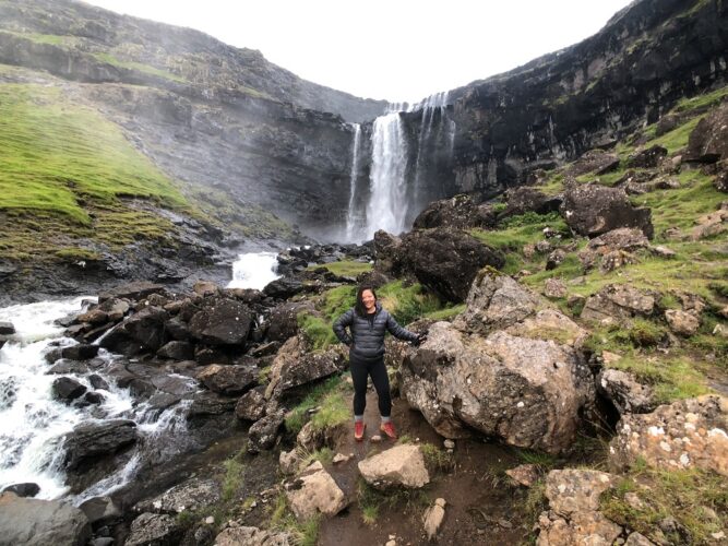 Dr. Aimee Zhang, MD hiking in front of a Waterfall 
