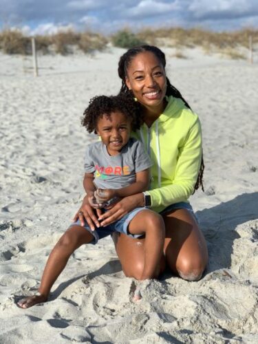 University of Virginia Elana Maccou, MD, Surgery Resident, smiles on the beach with her son.