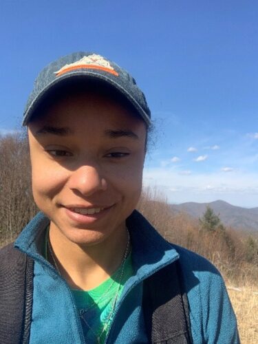 University of Virginia Rachel Williams, MD, Surgery Resident smiles on a hike outdoors.